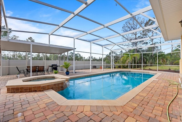 view of pool featuring a patio, fence, a pool with connected hot tub, and a lanai