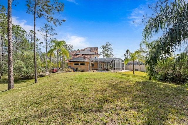 view of yard with a lanai and fence