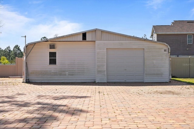 detached garage featuring fence