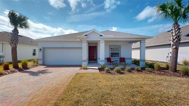 view of front facade with a porch, decorative driveway, an attached garage, and stucco siding