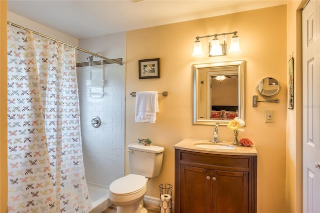 bathroom featuring a tile shower, vanity, and toilet