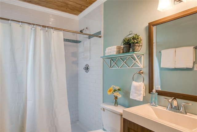 bathroom featuring toilet, ornamental molding, tiled shower, and vanity