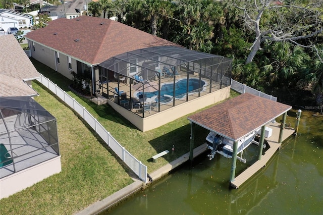 view of dock with a fenced in pool, a lawn, glass enclosure, boat lift, and a fenced backyard