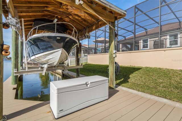 dock area featuring glass enclosure, a yard, and boat lift