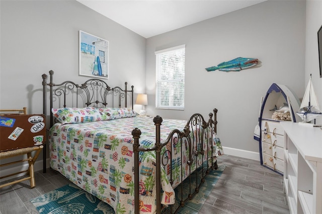 bedroom featuring baseboards and wood tiled floor