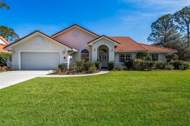 mediterranean / spanish home with a garage, concrete driveway, a tile roof, a front yard, and stucco siding