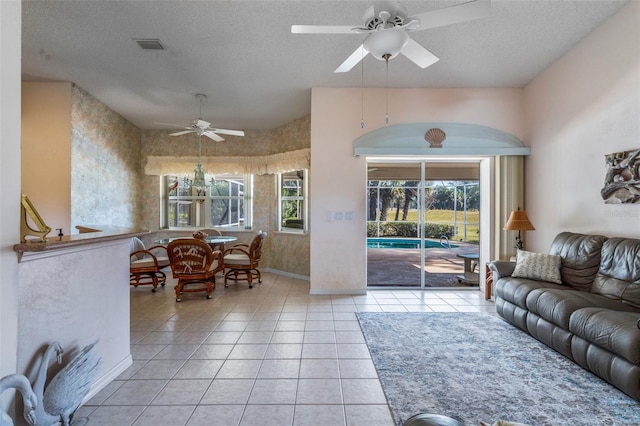 living room with a healthy amount of sunlight, light tile patterned floors, and a textured ceiling