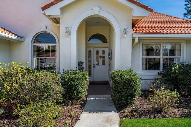 property entrance with a tiled roof and stucco siding