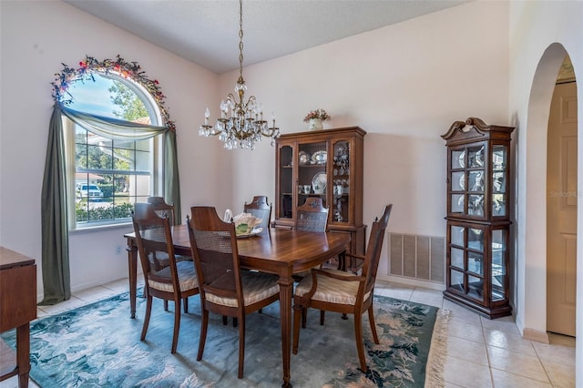 dining room featuring a chandelier, arched walkways, visible vents, and light tile patterned floors