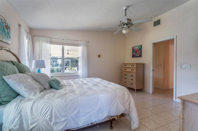 bedroom with visible vents, ceiling fan, a textured ceiling, and light tile patterned floors