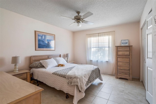 bedroom featuring ceiling fan, a textured ceiling, and light tile patterned flooring