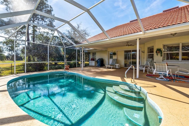 pool featuring a ceiling fan, glass enclosure, a patio, and area for grilling