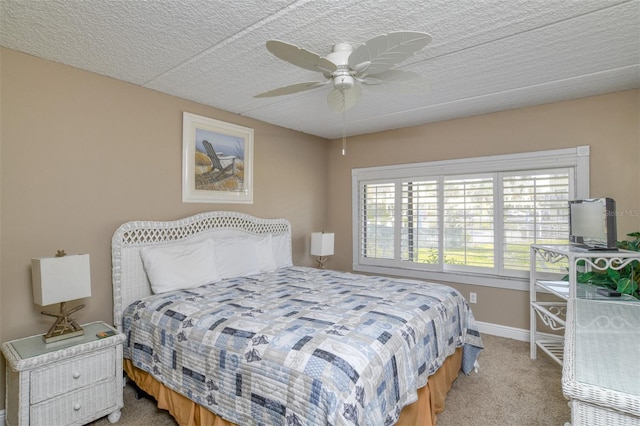 bedroom featuring a ceiling fan, carpet, baseboards, and a textured ceiling