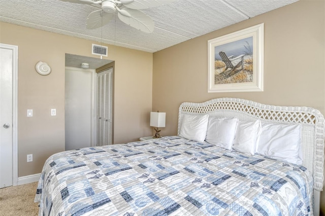 bedroom with a closet, visible vents, carpet flooring, ceiling fan, and baseboards