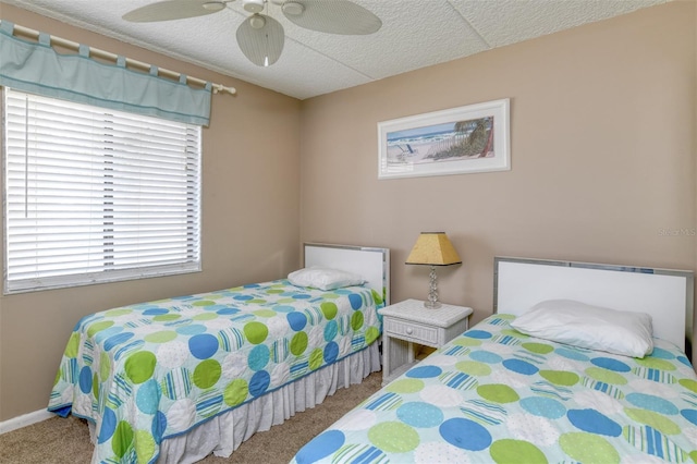 bedroom featuring carpet floors, a textured ceiling, baseboards, and a ceiling fan