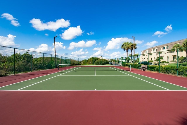 view of tennis court with community basketball court and fence