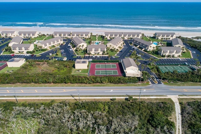 drone / aerial view with a water view, a view of the beach, and a residential view