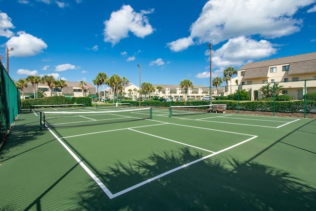 view of sport court featuring community basketball court, fence, and a residential view