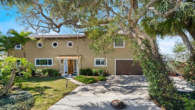 view of front of home featuring a front lawn, driveway, and an attached garage