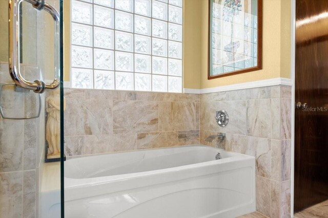 bathroom with tile walls and a bath