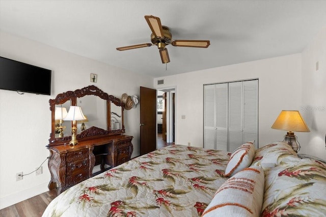 bedroom featuring a closet, wood finished floors, visible vents, and a ceiling fan