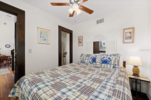 bedroom featuring ceiling fan, wood finished floors, and visible vents