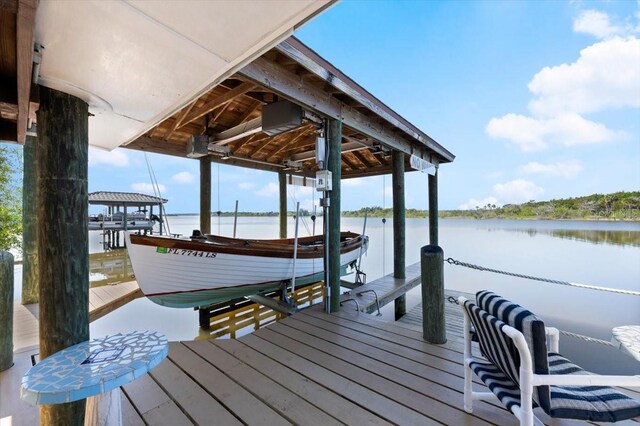 dock area with a water view and boat lift