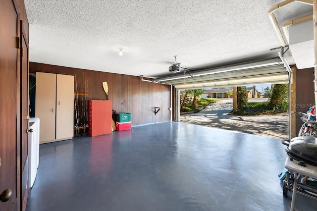 garage featuring wood walls and a garage door opener