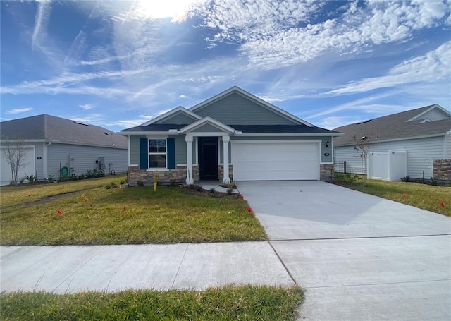 view of front facade featuring an attached garage, stone siding, concrete driveway, and a front yard