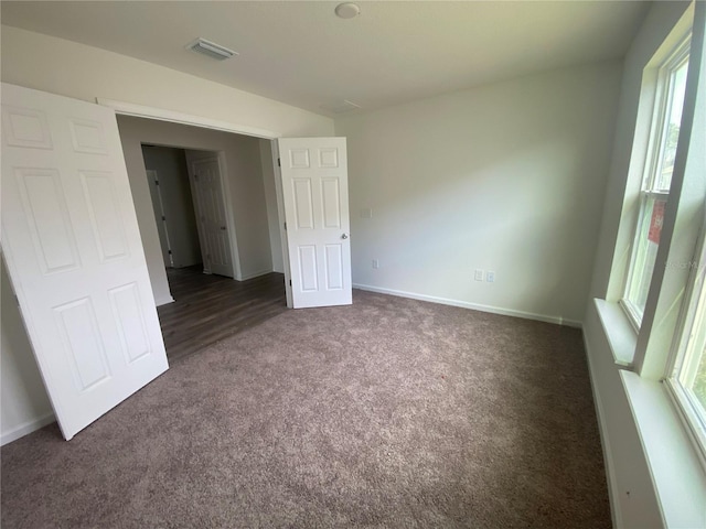 unfurnished bedroom featuring carpet floors, visible vents, and baseboards