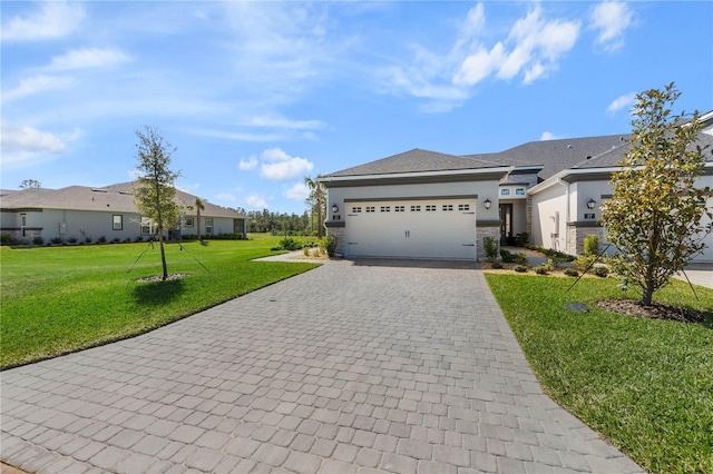 view of front of home featuring an attached garage, stone siding, decorative driveway, stucco siding, and a front yard