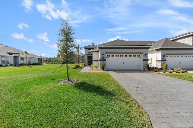 prairie-style house featuring a garage, a front lawn, decorative driveway, and stucco siding