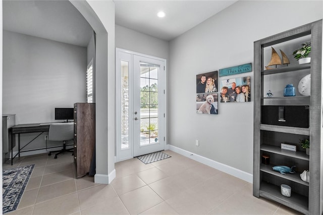 tiled entryway with arched walkways, french doors, recessed lighting, and baseboards