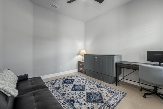 office space with a ceiling fan, visible vents, baseboards, and light tile patterned floors