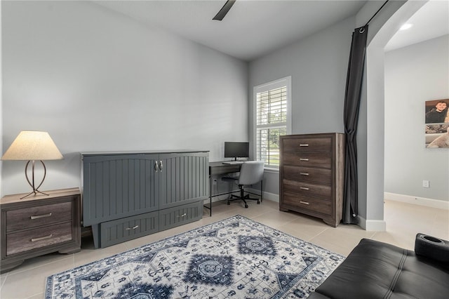 office area featuring light tile patterned flooring, a ceiling fan, and baseboards