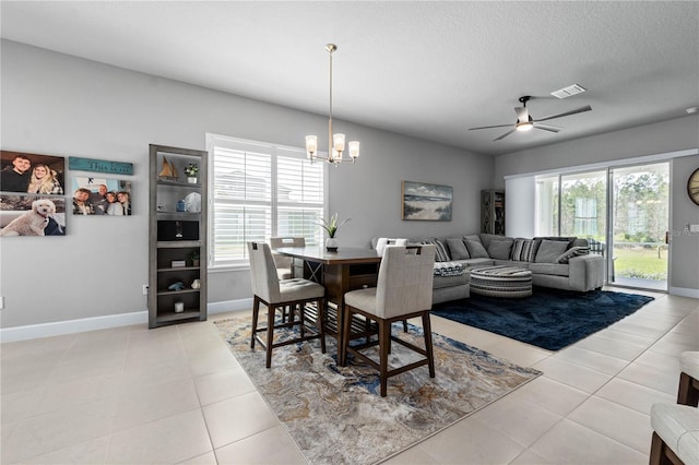 dining room with a textured ceiling, visible vents, a wealth of natural light, and light tile patterned flooring