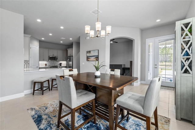 dining area featuring arched walkways, light tile patterned floors, recessed lighting, visible vents, and baseboards