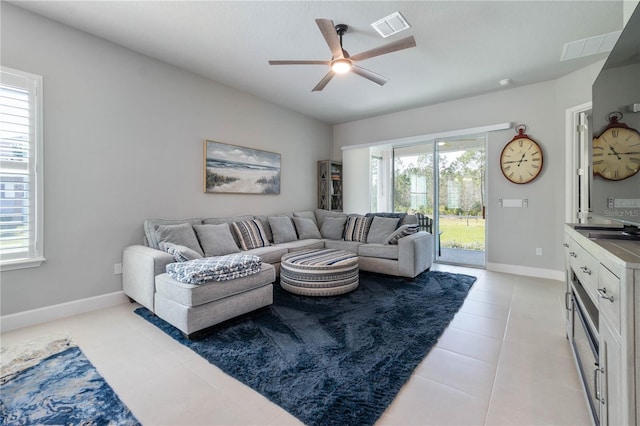 living room featuring visible vents, baseboards, ceiling fan, vaulted ceiling, and light tile patterned flooring