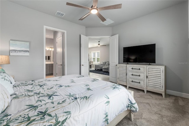 bedroom featuring ceiling fan, ensuite bathroom, light colored carpet, visible vents, and baseboards