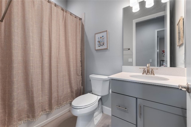 bathroom with toilet, shower / bath combo, baseboards, and vanity