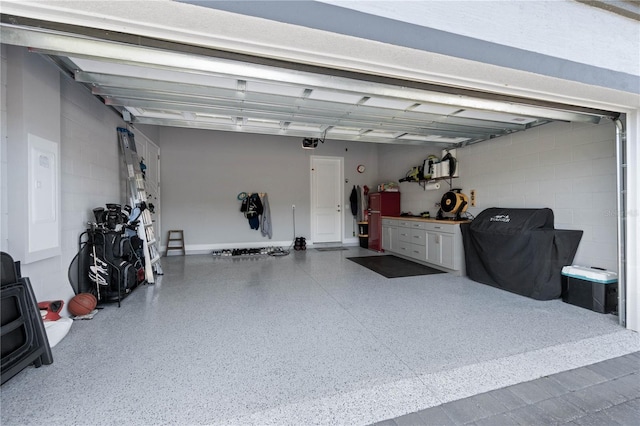 garage featuring a garage door opener and concrete block wall