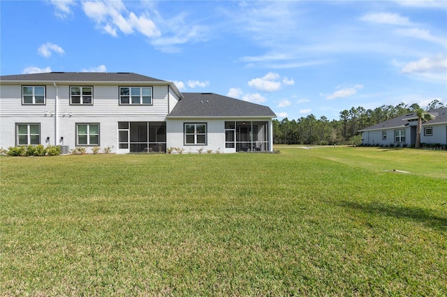 back of house featuring a yard and a sunroom