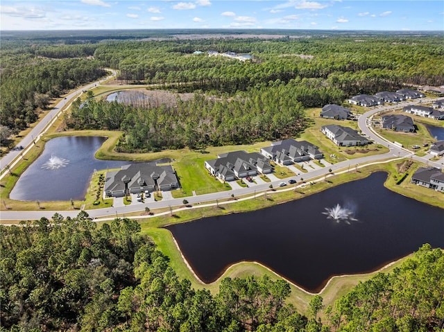 aerial view featuring a forest view, a water view, and a residential view