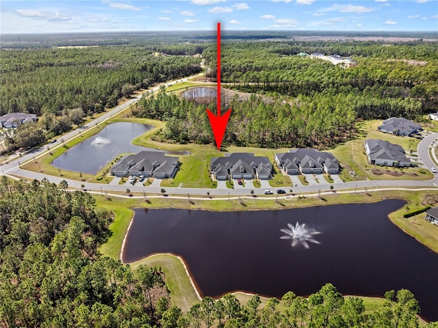 birds eye view of property featuring a water view and a forest view