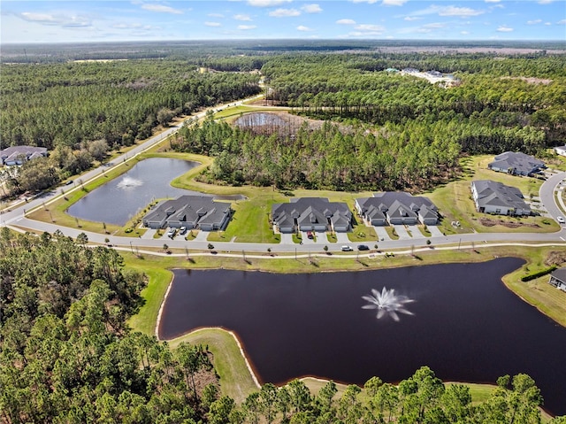 drone / aerial view with a water view, a residential view, and a view of trees