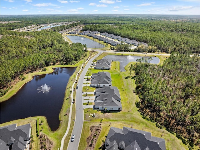 drone / aerial view featuring a water view and a forest view