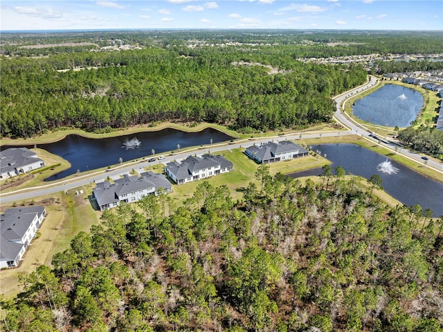 birds eye view of property with a water view and a wooded view