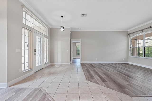 entrance foyer with a wealth of natural light, baseboards, and crown molding