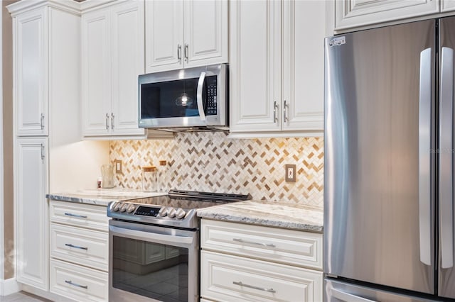 kitchen with white cabinetry, decorative backsplash, light stone countertops, and appliances with stainless steel finishes