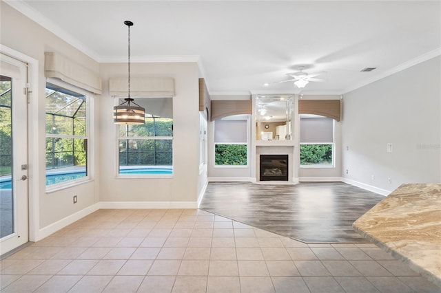 unfurnished living room featuring tile patterned floors, a large fireplace, baseboards, and crown molding